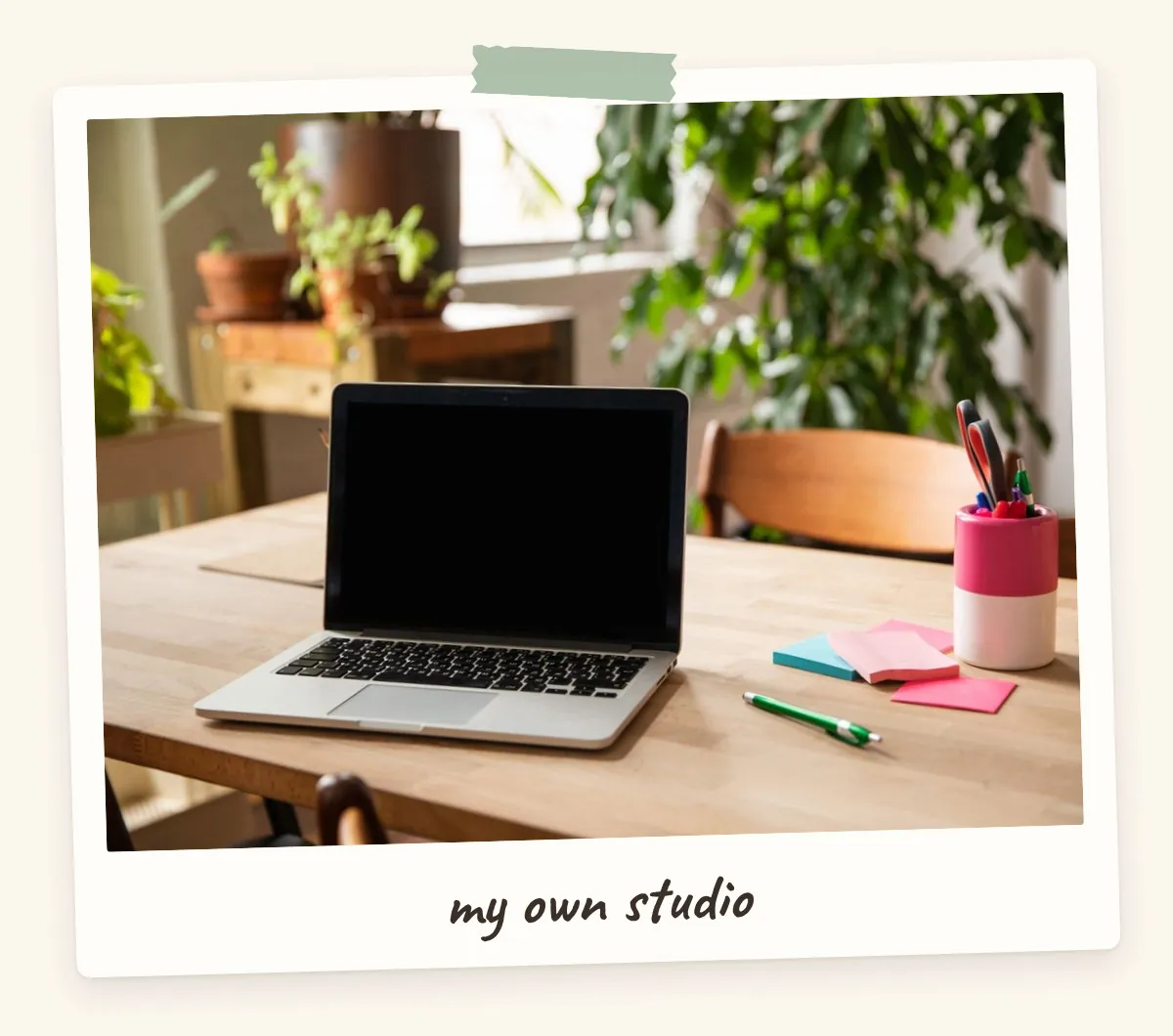 Sunny home office desk with laptop, plants and pink sticky notes for a career vision board